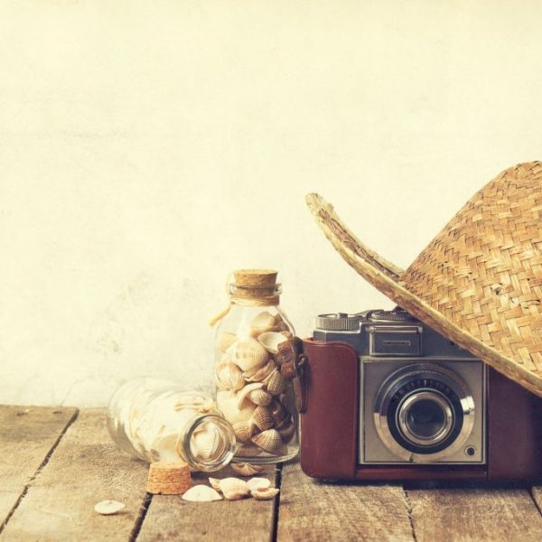 Summer or vacation concept. Straw hat with old vintage camera an